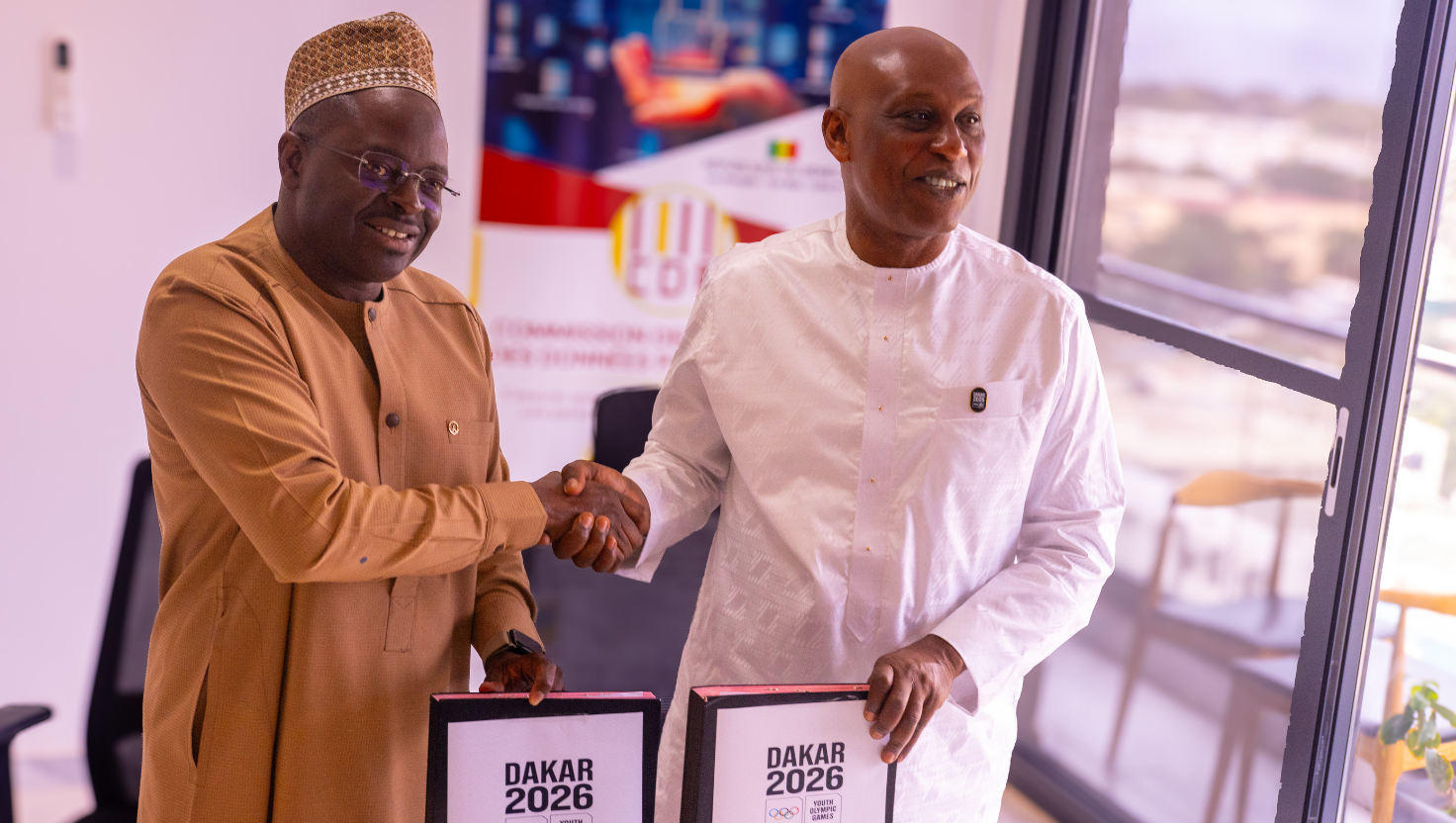 Officials holding Dakar 2026 Youth Olympic Games agreement folders
