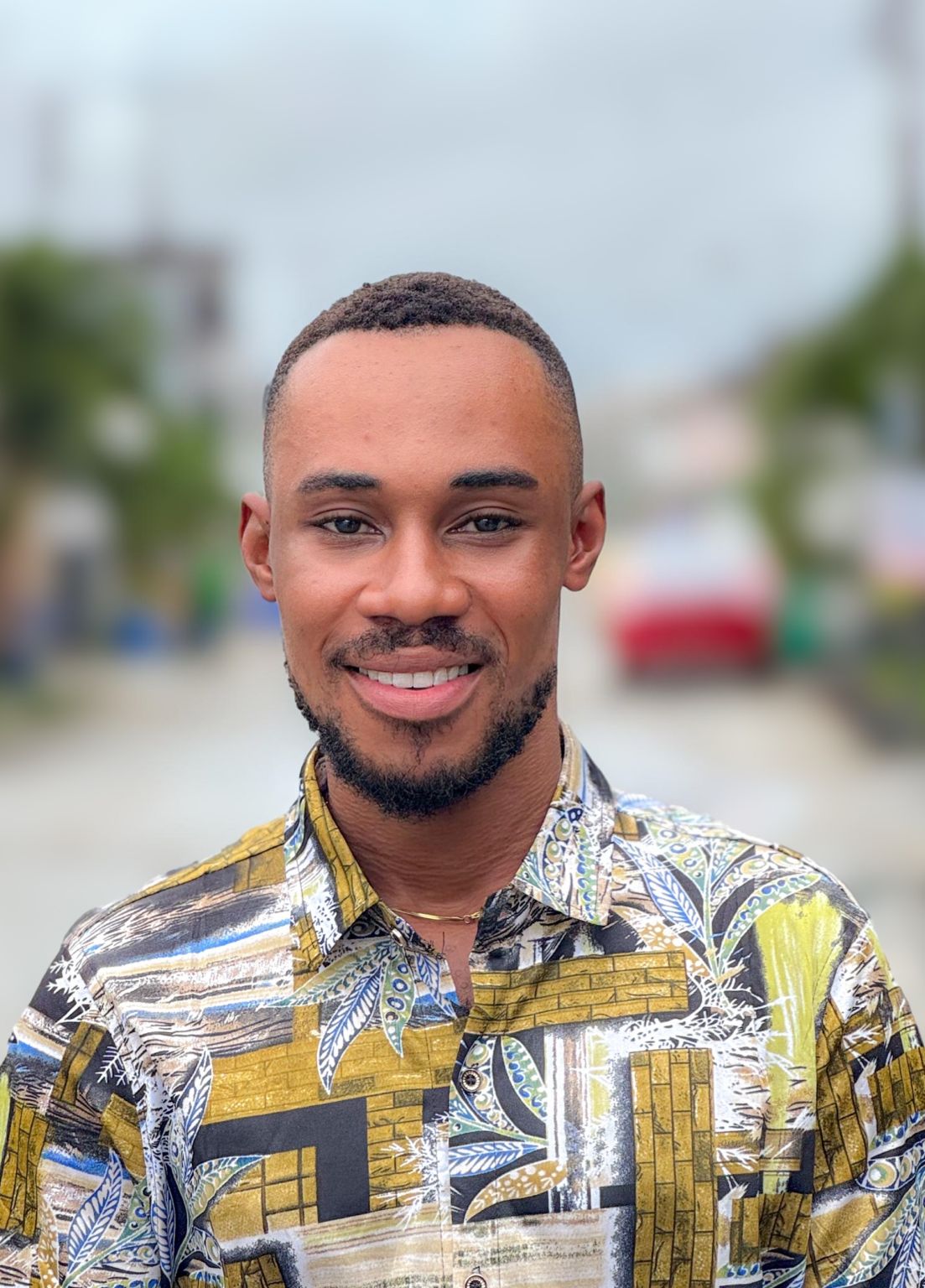 Portrait supplied to Afridiaspo for the Joshua Udezuka story; a smiling man in a patterned shirt outdoors