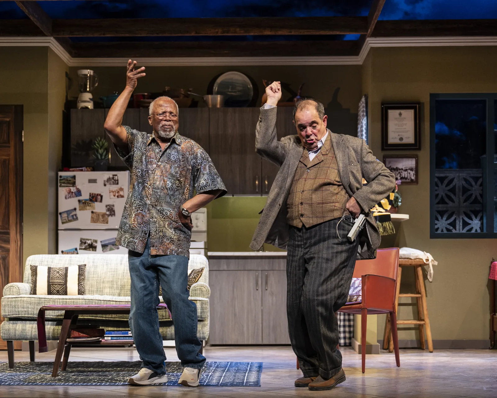 John Kani and Edward Gero standing with their arms raised in Kunene and the King.